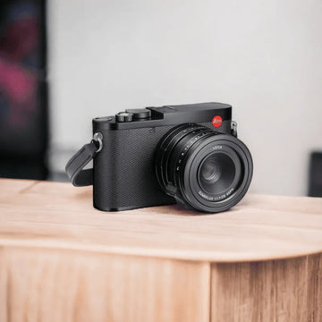 Boîtier Leica Q2 noir posé sur un présentoir en bois